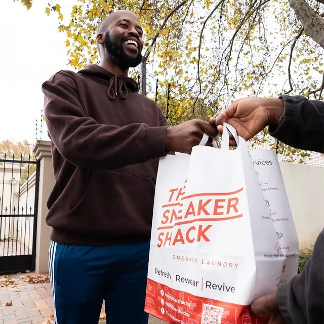 Customer receiving a Sneaker Shack pickup and delivery bag at their door